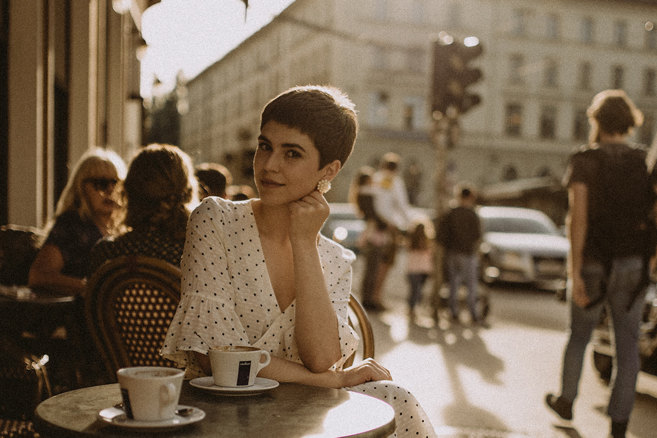 カフェでコーヒーを飲むショートヘアの女性